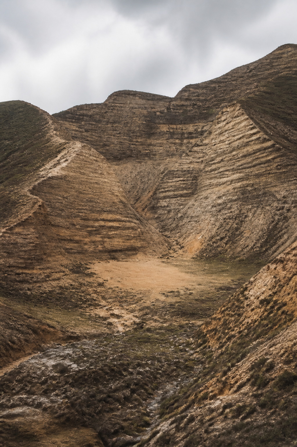 Stratified ochre mountain and loess formations enclosing a quiet center
